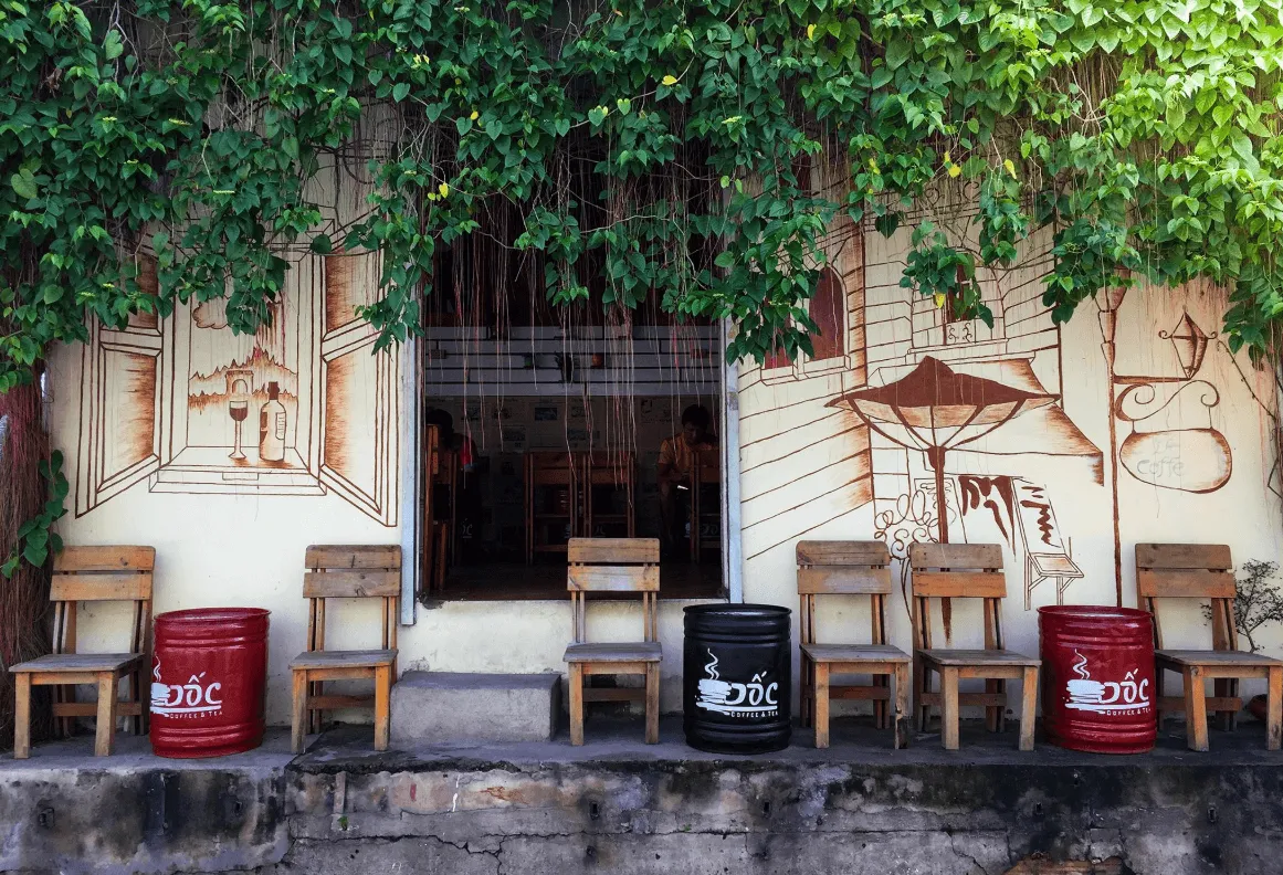 Bàn ghế gỗ tự nhiên và ghế sofa tạo cảm giác thân thiện ấm cúng cho không gian quán cà phê