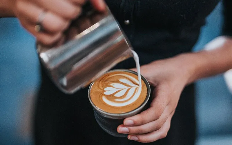 Barista đang thực hiện kỹ thuật rót sữa để tạo hình Latte Art