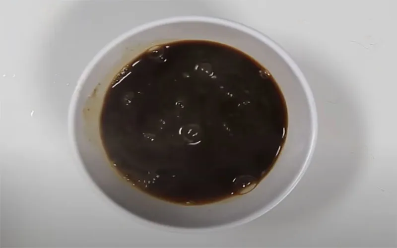 Cà phê đen được pha bằng nước sôi và đang được khuấy đều cho tan hoàn toàn, là bước nền quan trọng trong cách làm sữa chua cà phê tại nhà