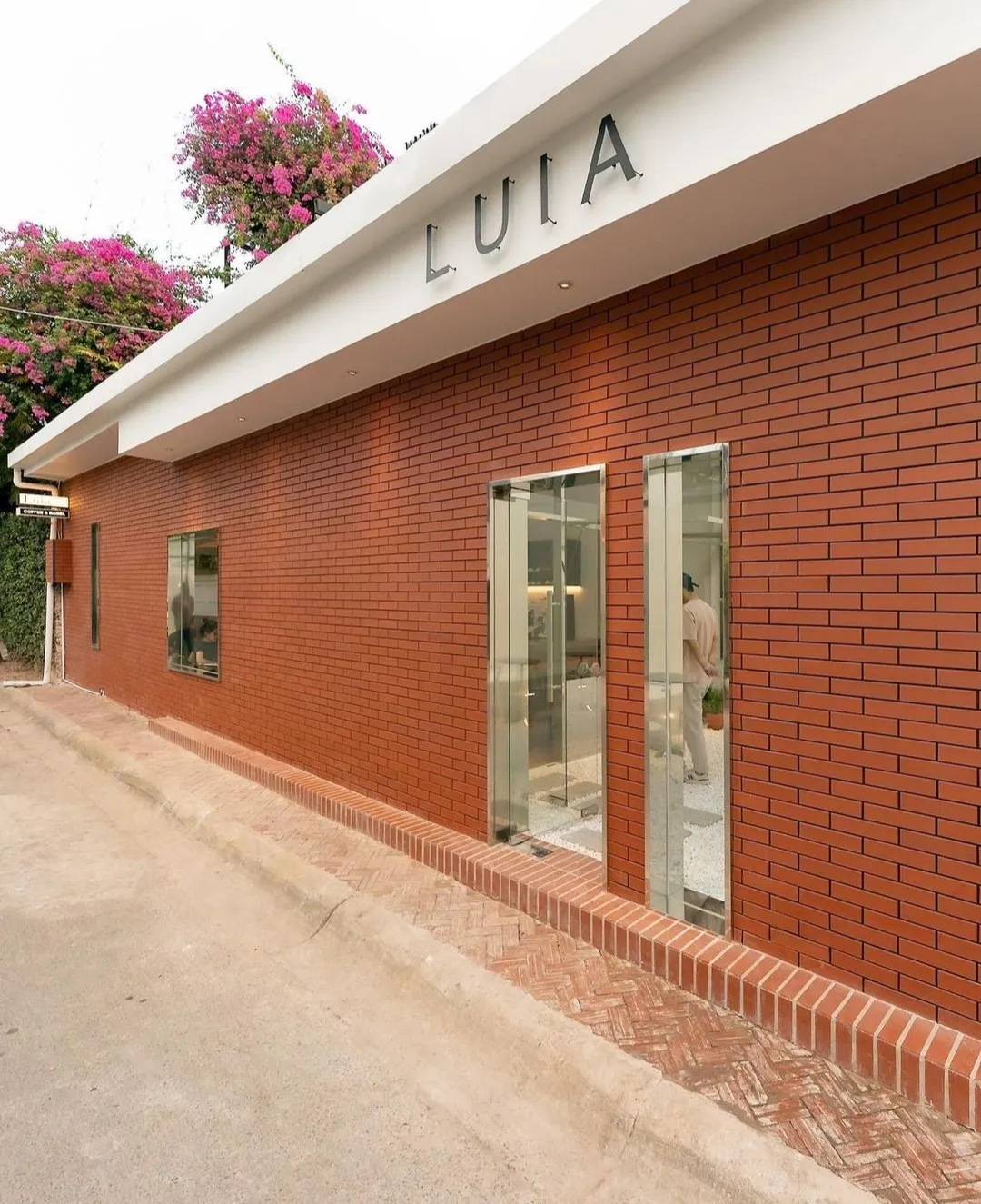 Cafe Luia sử dụng tone xám trắng và vách kính để tối ưu không gian