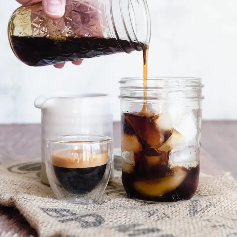 Đá viên, siro đường và sữa tươi lạnh đã được cho vào ly, tạo nền cho cà phê latte đá