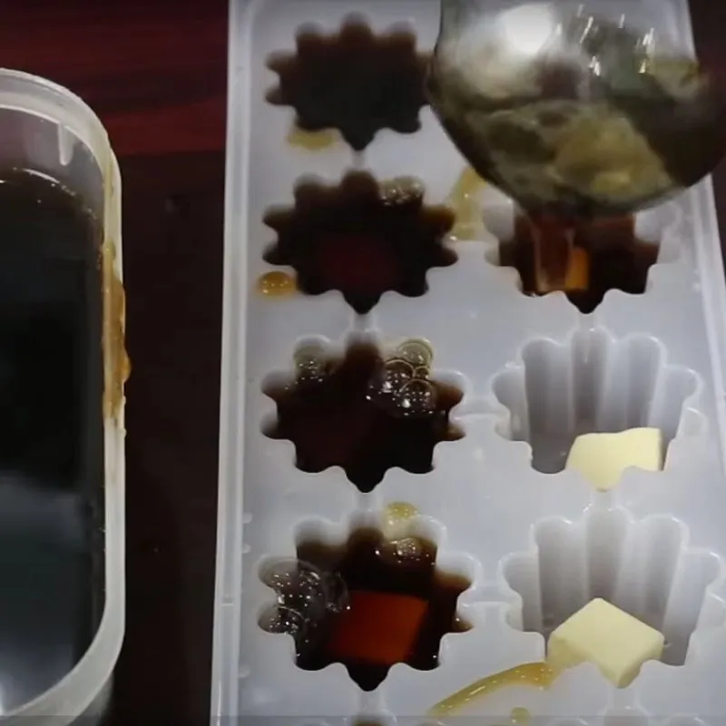 Đổ hỗn hợp thạch rau câu cà phê đã lọc vào khuôn có sẵn nhân phô mai con bò cười đã được cắt nhỏ