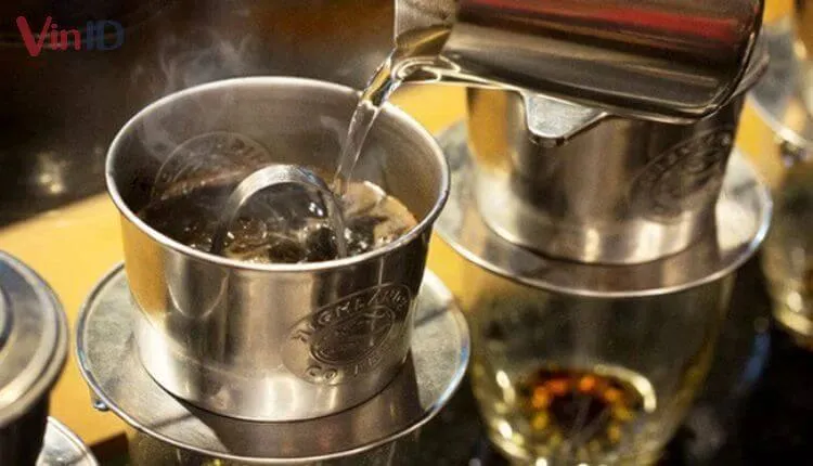 Đổ nước sôi lần thứ hai vào phin để hoàn tất quá trình chiết xuất cà phê