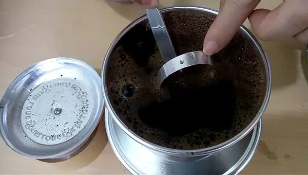 Dùng dụng cụ ấn phin xuống một cách nhẹ nhàng và dứt khoát để tăng độ nén sau khi ủ lần đầu