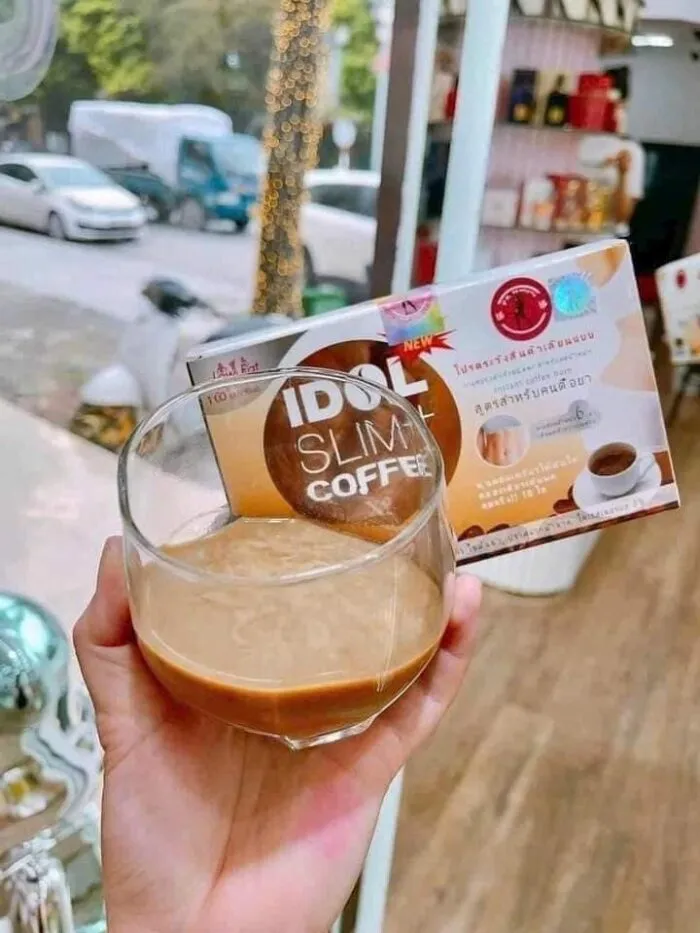 Gói cà phê giảm cân Slim Idol Coffee được đặt bên cạnh hạt cà phê và chén nhỏ
