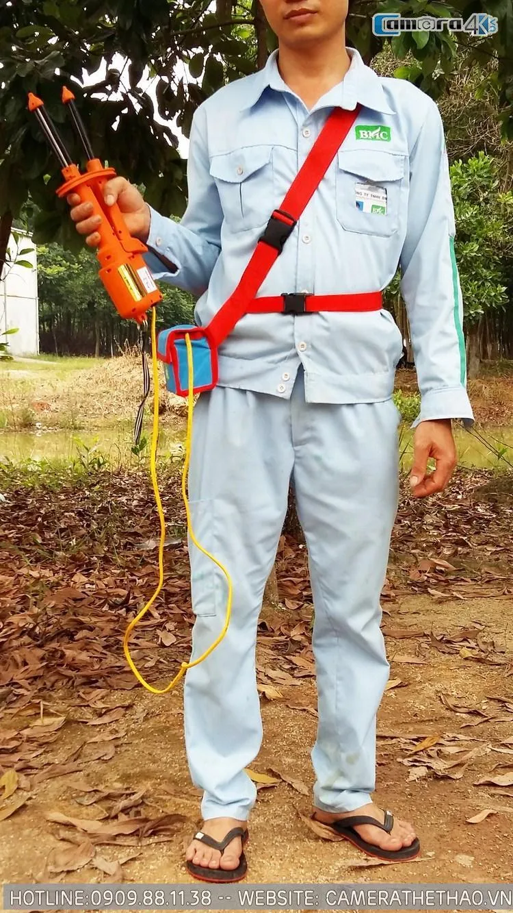 Hình ảnh cận cảnh máy hái cà phê cầm tay BMC đang hoạt động trên cành cà phê