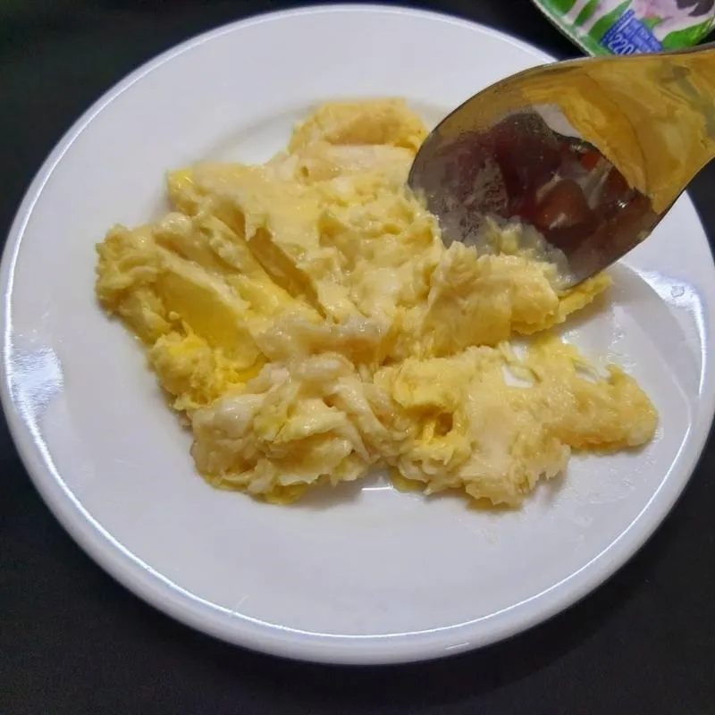 Hình ảnh cơm sầu riêng đã được dằm nhuyễn một phần trong chén, chuẩn bị cho bước pha chế