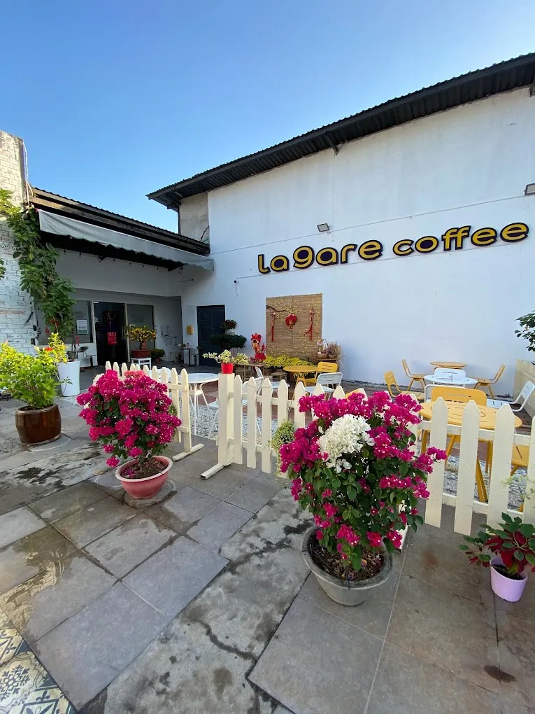 Hình ảnh không gian bên trong Cafe de la Gare với các vật dụng vintage, mô hình tàu và khung hình slogan độc đáo