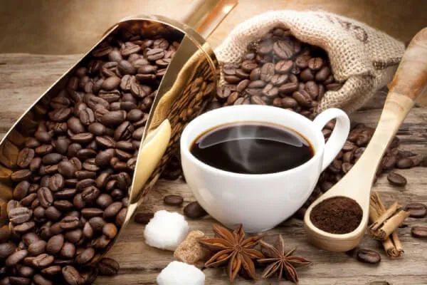 Hình ảnh một chén chứa đầy hạt cà phê rang, minh họa lợi ích tiềm năng của hạt cà phê đối với cơ thể