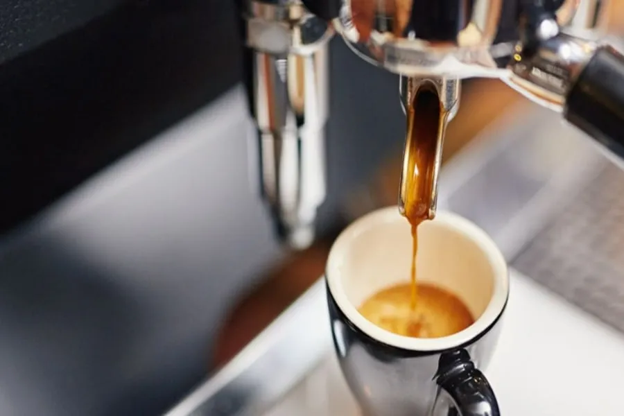 Hình ảnh một người đang thưởng thức cà phê Espresso, tập trung vào hương thơm và vị đắng nhẹ