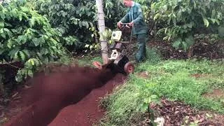 Hình ảnh người nông dân đang kiểm tra và bảo dưỡng máy đào hố ép xanh sau khi sử dụng