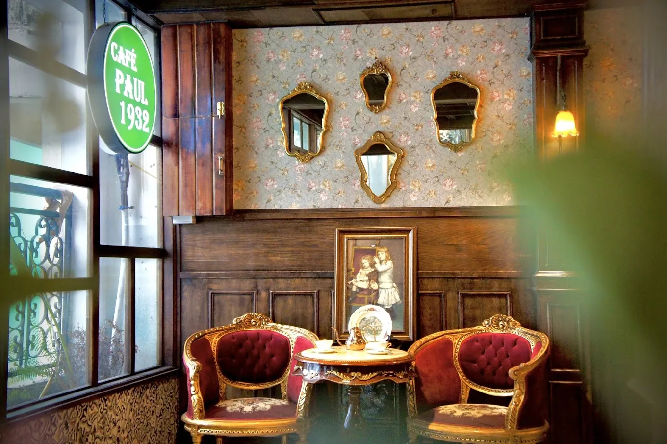 Hình ảnh nội thất Café Paul 1932 với ánh sáng ấm áp, bàn ghế gỗ cổ điển và các chi tiết trang trí vintage