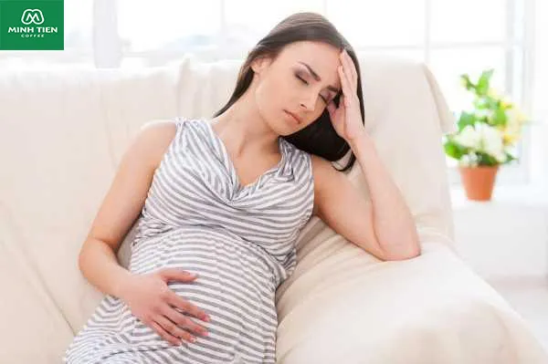 Hình ảnh phụ nữ mang thai đang dùng tay che bụng, ngụ ý không nên uống cà phê khi đang có thai