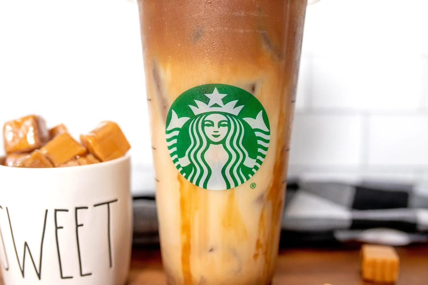 Logo Starbucks trên cốc giấy, tượng trưng cho công thức Iced Caramel Macchiato chuẩn vị