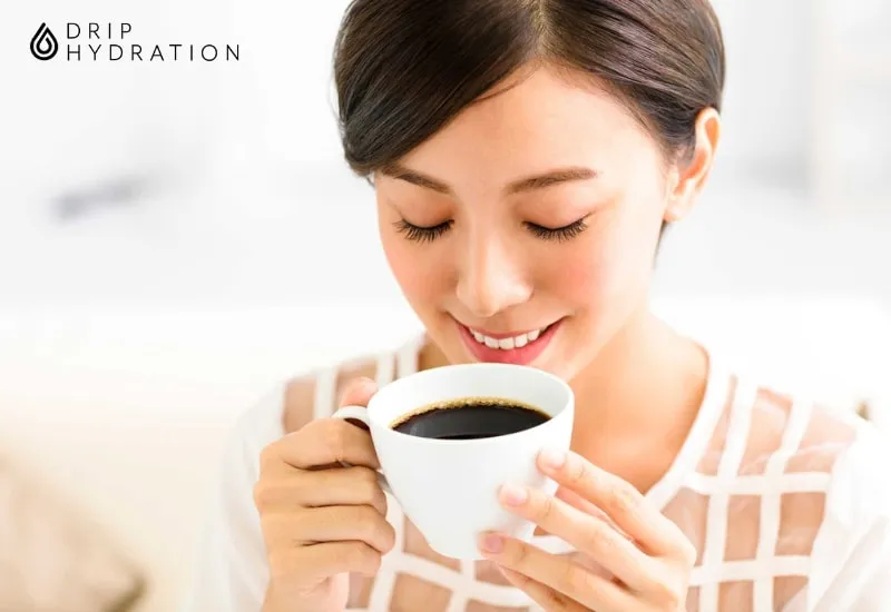 Ly cà phê đen nguyên chất được đặt cạnh máy chạy bộ, tượng trưng cho việc uống cà phê có giảm mỡ bụng không khi kết hợp tập luyện