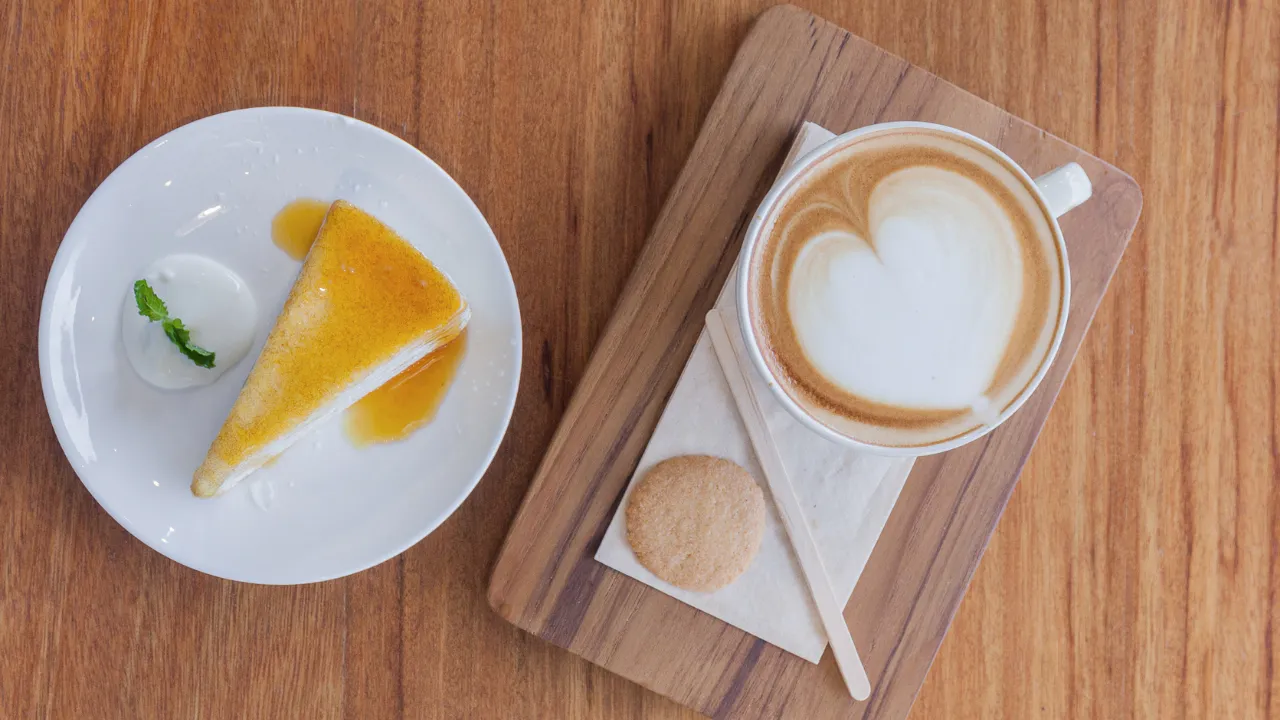 Ly Cappuccino hoàn hảo với lớp bọt sữa mịn màng, kết hợp bánh ngọt