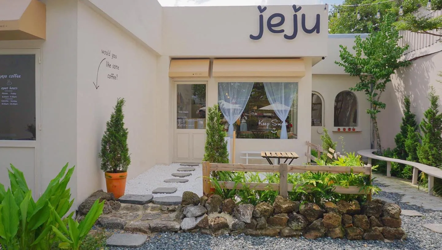 Mặt tiền tối giản tông trắng của JeJu Coffee kết hợp hài hòa với cây xanh