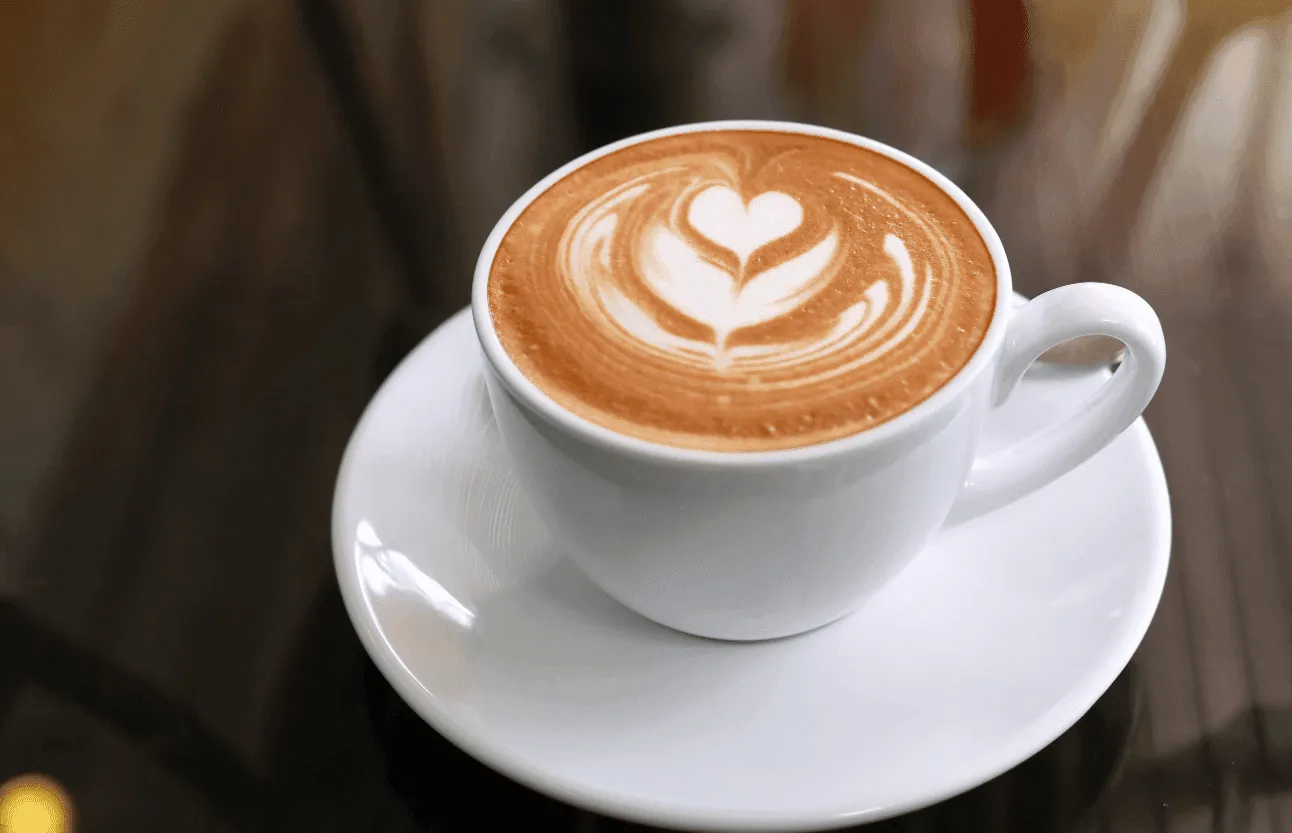 Minh họa một ly cà phê latte được pha chế và trang trí latte art đẹp mắt, thể hiện kỹ thuật microfoam chuẩn