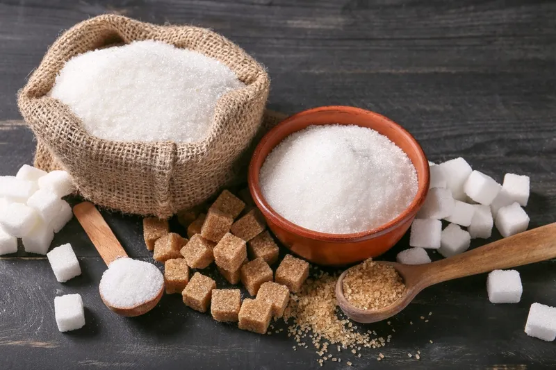 Mô tả ảnh: Các nguyên liệu pha cà phê sữa lành mạnh như sữa tươi không đường, cà phê hạt nguyên chất và đường ăn kiêng được bày trên bàn