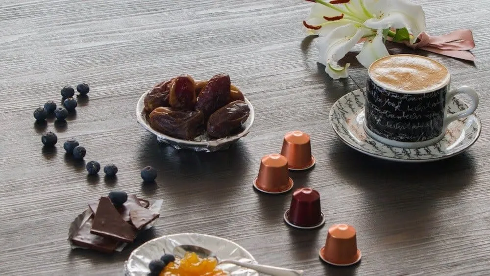 Mô tả các viên nén cà phê được đặt gần cốc và máy pha chuyên dụng