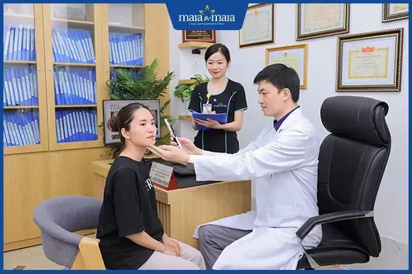 Mô tả hình ảnh bệnh nhân đang được bác sĩ da liễu thăm khám, thể hiện sự cần thiết của điều trị chuyên nghiệp