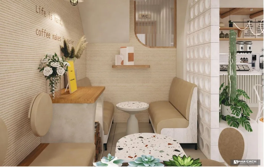 Một dãy bàn vuông và ghế đẩu nhỏ gọn, hiện đại được bố trí sát tường trong không gian quán cà phê nhỏ