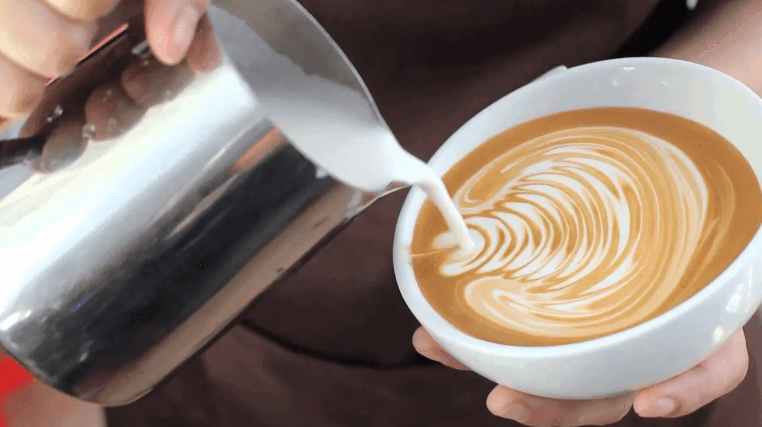Một ly cà phê latte được đặt cạnh bánh croissant bơ, gợi ý kết hợp món ăn hoàn hảo để cân bằng vị giác