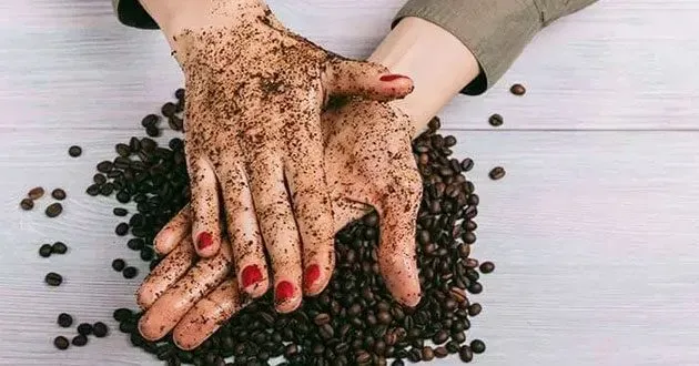 Một người đang thoa hỗn hợp tẩy tế bào chết bằng bã cà phê lên tay để loại bỏ da chết