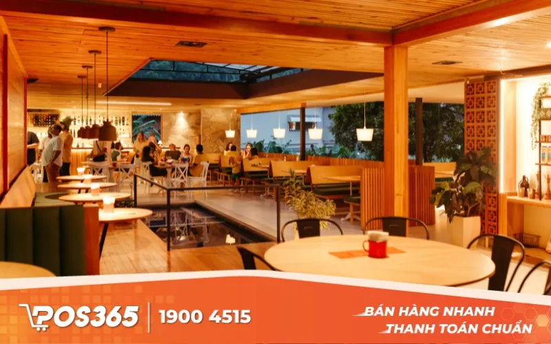 Một nhân viên đang dắt xe cho khách nữ trước cửa quán cà phê