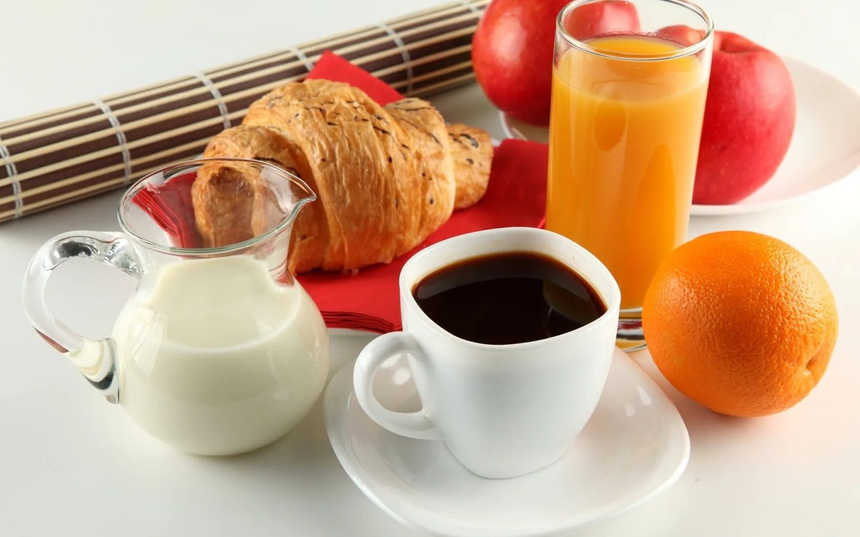 Một tách cà phê đặt cùng hoa quả, minh họa cho việc uống cà phê đúng cách để không bị ảnh hưởng đến huyết áp
