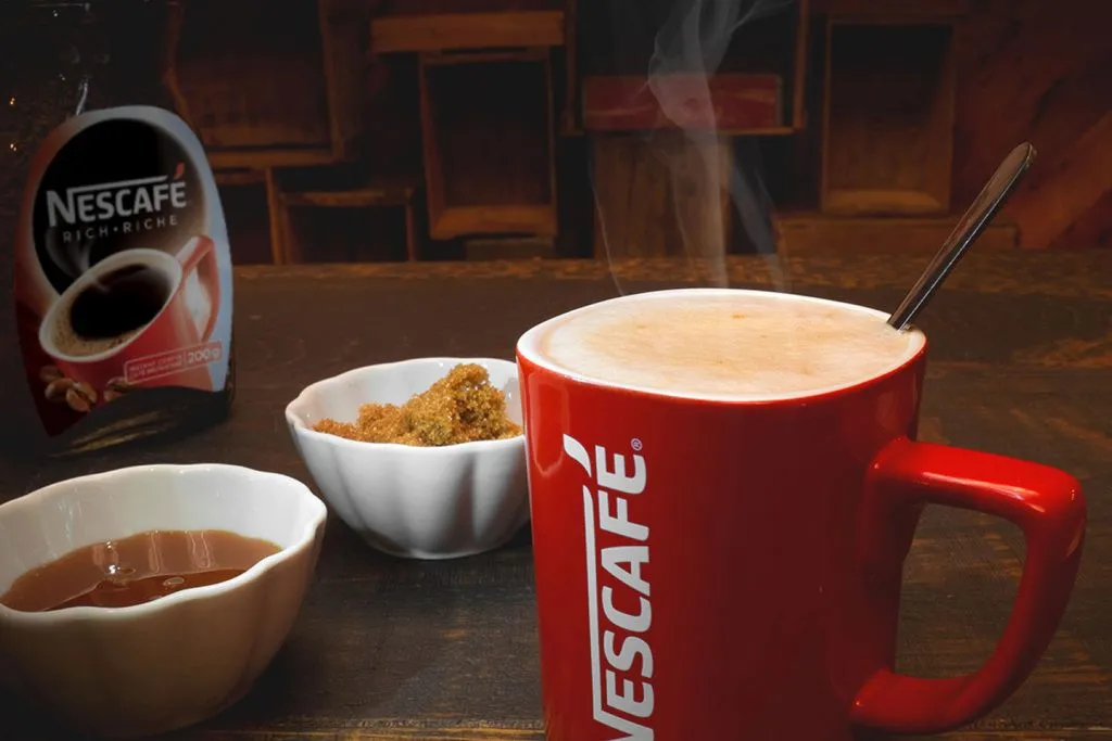 Người đang khuấy ly cà phê Nescafe hòa tan nóng, hướng dẫn cách pha cà phê Nescafe