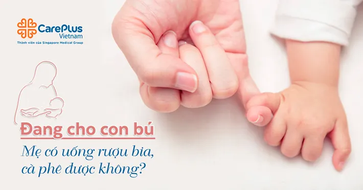 Người mẹ đang ôm con và uống cà phê, minh họa cho chủ đề cho con bú có uống được cà phê