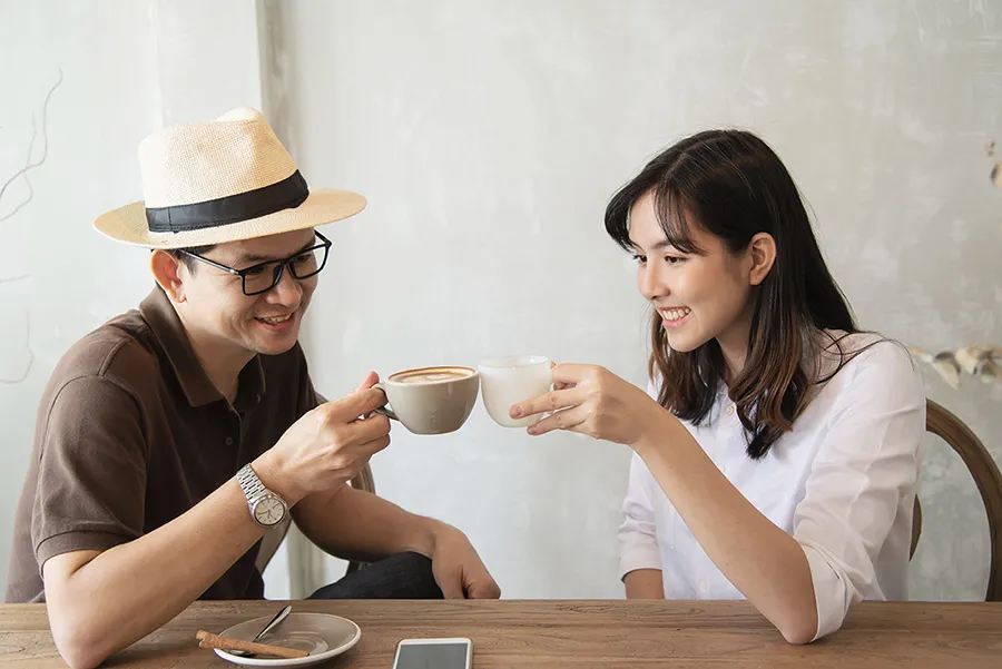 Người phụ nữ đang làm việc bên máy tính với tách cà phê, thể hiện sự tỉnh táo nhưng có thể bị quá liều caffeine nếu uống nhiều