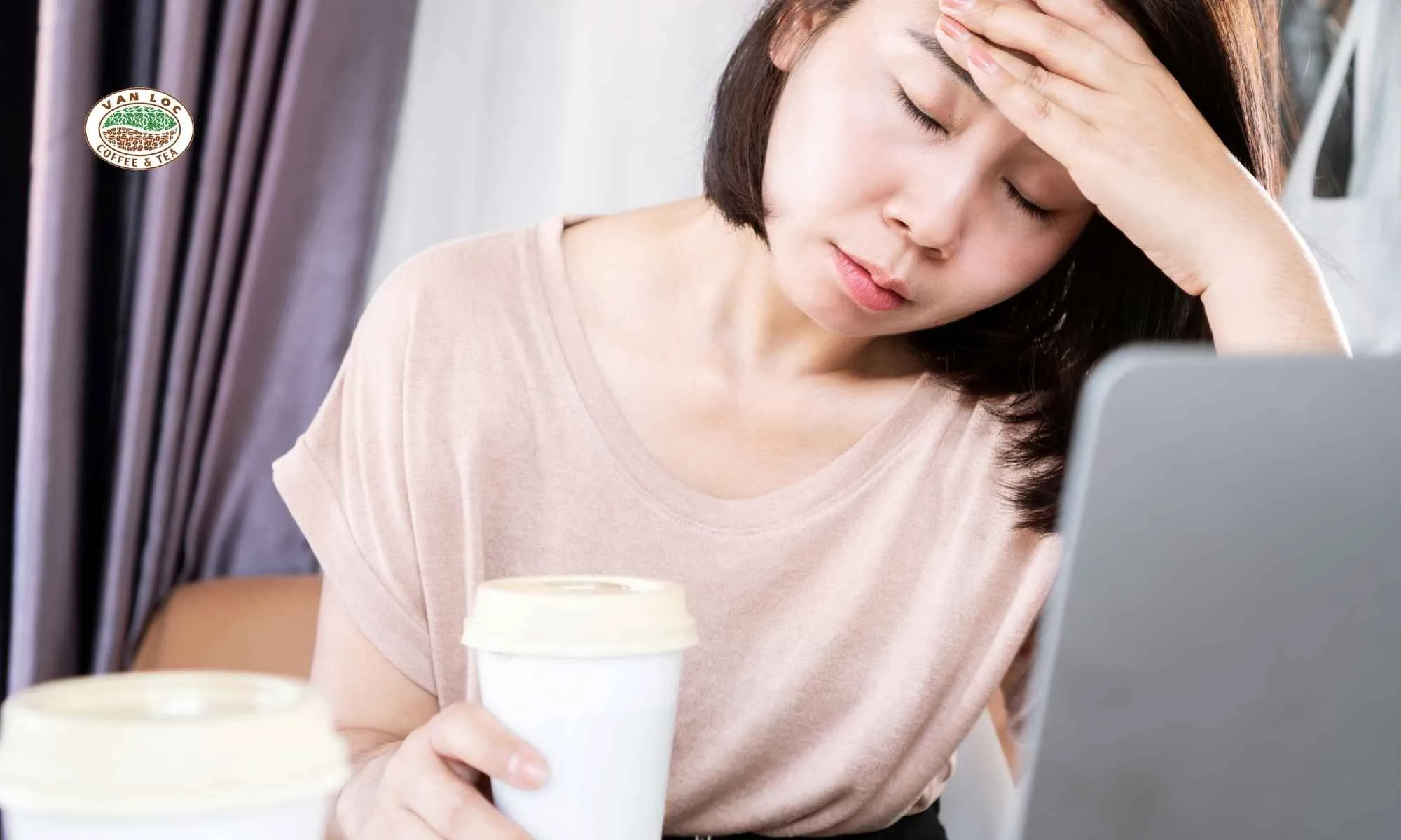 Người phụ nữ tỏ ra khó chịu hoặc mệt mỏi vì bị mất ngủ do cà phê