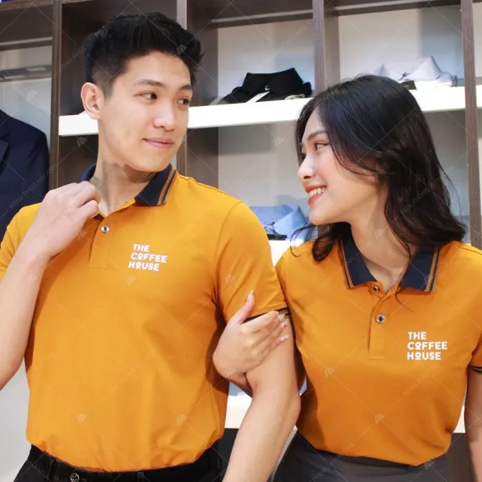 Nhân viên mặc đồng phục polo vàng nghệ tại quầy