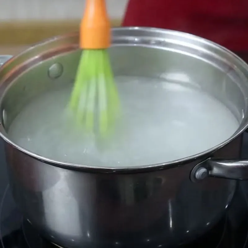 Quá trình nấu thạch rau câu với cà phê đen hòa tan được khuấy đều trên bếp lửa vừa để hỗn hợp bột rau câu tan hoàn toàn
