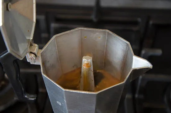 Quy trình chiết xuất cà phê Moka diễn ra, chất lỏng màu nâu sẫm đang chảy lên bình chứa phía trên.